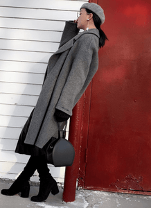 a woman in winter look holding ATENA BLACK PURSE-SLING BAG - MDLR