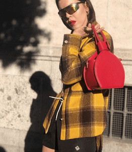 A woman carrying in her shoulder ATENA RED PURSE-SLING BAG, a red bag, red handbag, with minimalist look from MDLR